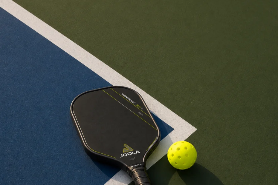 Pickleball paddle and ball on an indoor court at Grosse Ile Athletic Club